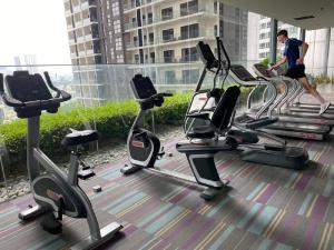 a man walking through a gym with cardio machines at Mercu Summer Suite by Great Service in Kuala Lumpur