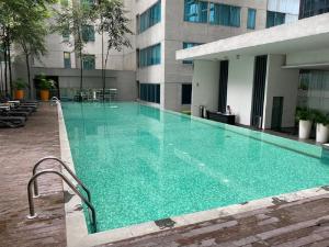 a large swimming pool in front of a building at Mercu Summer Suite by Great Service in Kuala Lumpur