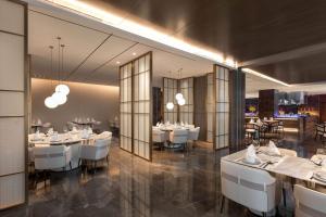 a dining room with white tables and white chairs at Wyndham Taizhou West in Taizhou