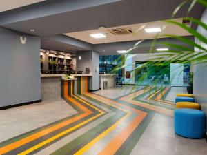 una hall con pavimenti colorati e un bar di ibis Styles Goiânia Shopping Estação a Goiânia