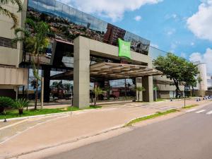 um edifício com um sinal verde em frente em ibis Styles Goiânia Shopping Estação em Goiânia