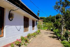 a white building with plants on the side of it at St Elmo Homestay in Nuwara Eliya