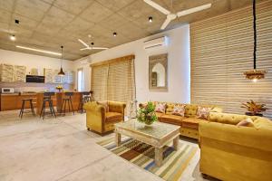 a living room with a couch and a table at Manna Villa in Mahabalipuram