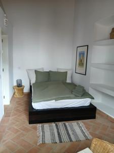 uma cama num quarto com uma parede branca em Casa d´Alte em Alte