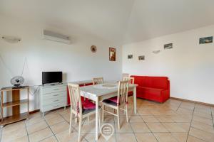comedor con mesa y sofá rojo en Mirto 3 Apartment, en Santa Maria Navarrese