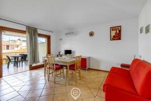 Una sala de estar con una mesa y un sofá rojo. en Mirto 3 Apartment, en Santa Maria Navarrese