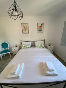 a bedroom with a large white bed with towels on it at Casa do Balcão in Meda