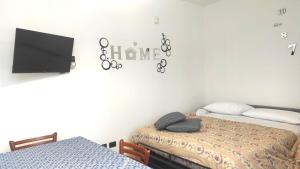 - une chambre avec 2 lits et une télévision murale dans l'établissement Donatellaguesthouse, à Piove di Sacco