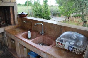 ein Waschbecken in einer Küche mit Fenster in der Unterkunft Country House in Paralia Dionisiou