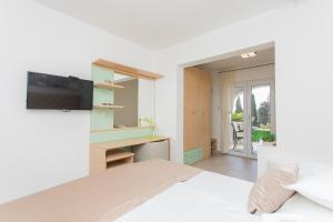 una camera da letto con un letto e una TV a parete di Apartments Villa Nena a Bol