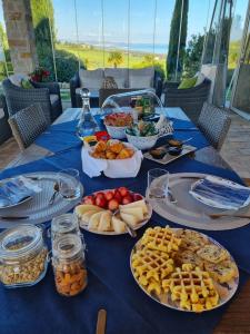 a blue table with plates of food on it at Colle degli ulivi Green Resort in Petacciato