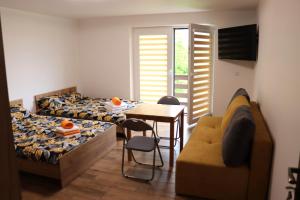 a bedroom with a bed and a table and a couch at Apartamenty Zator Energy Rest in Zator