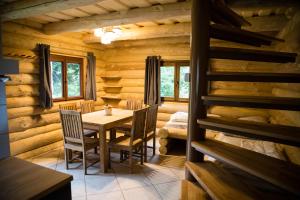 Relax S-L-A-P-Y Resort - Mlýn v zátoce في Borotice: غرفة طعام في كابينة خشب مع طاولة وكراسي