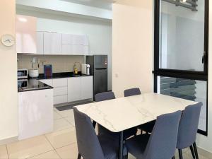 a kitchen with a table and chairs in a room at Lovely Eco Home in Gelang Patah