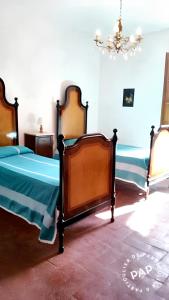 een slaapkamer met 2 bedden en een kroonluchter bij 4 bedrooms house with furnished terrace at Citta Metropolitana di Firenze in Compiobbi