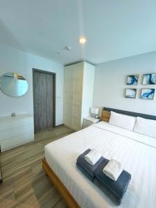 ナイヤンビーチにあるThe Title Residences, Naiyang Beach, Phuketのベッドルーム1室(大型ベッド1台、タオル2枚付)