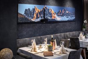 comedor con mesa con manteles blancos y copas de vino en Hotel Tyrol, en Bresanona
