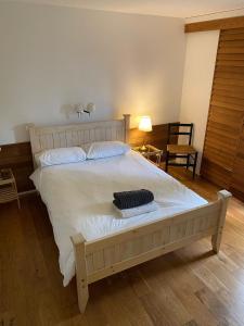 een slaapkamer met een groot wit bed met een houten hoofdeinde bij Wood Place in Diss