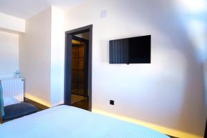 - une chambre avec un lit et une télévision murale à écran plat dans l'établissement TİRİLYE BALIK OTEL, à Eskipazar