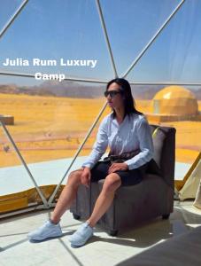 una mujer sentada en una silla con las piernas cruzadas en Julia Rum Luxury Camp en Wadi Rum