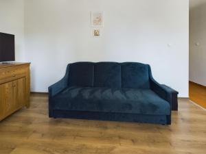 un sofá azul en una sala de estar junto a una TV en Gdynia City Centre Apartment Abrahama by Renters, en Gdynia