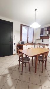 - une salle à manger avec une table et des chaises en bois dans l'établissement Donatellaguesthouse, à Piove di Sacco