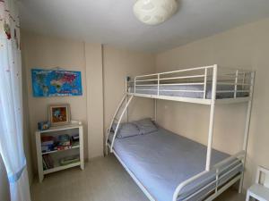 a bedroom with two bunk beds and a shelf at Bajo con Jardin y Piscina! in Galizano