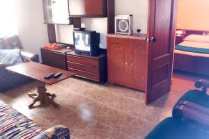 een woonkamer met een bank, een tv en een tafel bij 3 bedrooms house with enclosed garden and wifi at Rada in Mélida