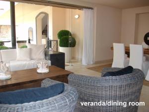 sala de estar con sofá blanco y sillas en casagratiaone en Taormina