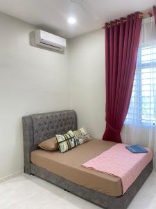 - un lit dans une chambre dotée d'un rideau rouge dans l'établissement MJ Homestay Kota Bharu, à Kota Bharu