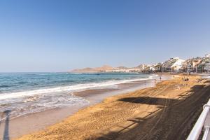 una playa de arena con el océano y edificios en ella en Home2Book Cozy Escape near Las Canteras Beach, en Las Palmas de Gran Canaria
