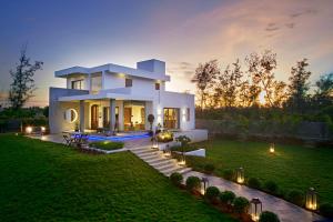 a large white house with lights in the yard at Manna Villa in Mahabalipuram