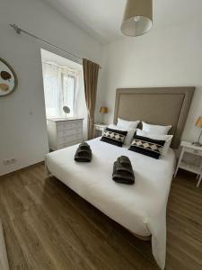 ein Schlafzimmer mit einem großen weißen Bett mit zwei Handtüchern darauf in der Unterkunft Casa Nova Vida in Paderne