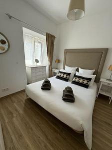 a bedroom with a large white bed with two towels on it at Casa Nova Vida in Paderne +20 photos