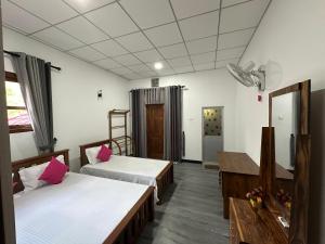 Pokój hotelowy z 2 łóżkami i lustrem w obiekcie Pharo Residence w mieście Anuradhapura