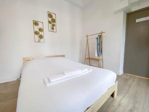 a white bed in a room with a wooden floor at Hotel Le Céleste in Nice