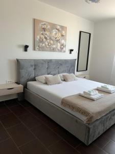 a bedroom with a large bed with a painting on the wall at Vitas Apartments in Zaton