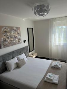 a bedroom with a large bed with two towels on it at Vitas Apartments in Zaton