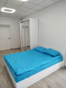 a bed in a white room with blue sheets at Aydeniz hostel in Chişinău