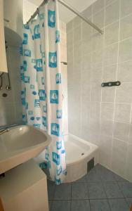 a bathroom with a shower curtain and a tub and a sink at Studio Lokvica in Omišalj +24 photos