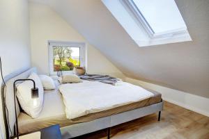 a bedroom with a bed with a skylight at De Strandloper in Westerdeichstrich