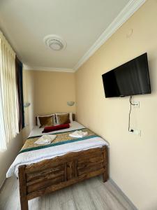 a bedroom with a bed with a flat screen tv on the wall at Happy Suite Boutique Hotel in Istanbul