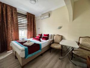 イスタンブールにあるHappy Suite Boutique Hotelのベッドルーム1室(赤い枕と椅子付きのベッド1台付)