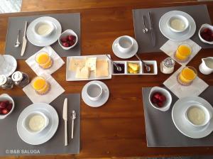 a table with plates of cheese and cups of orange juice at B&B Saluga Sehel Island Nubian House in Aswan