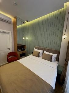 The Aramis Galata Hotel في إسطنبول: غرفة نوم بسرير كبير وكرسي احمر