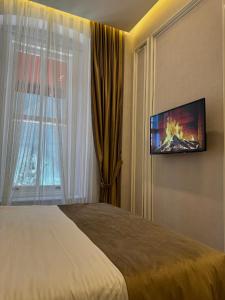 Habitación de hotel con cama y TV de pantalla plana. en The Aramis Galata Hotel, en Estambul