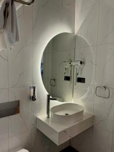 uma casa de banho branca com um lavatório e um espelho em The Aramis Galata Hotel em Istambul