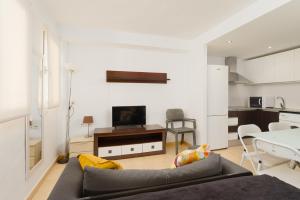 a living room with a couch and a table with a tv at Port de Xabia V in Jávea