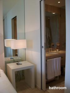 un baño con una lámpara sobre una mesa y un lavabo en casagratiaone en Taormina