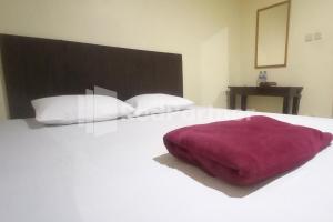 En eller flere senger på et rom på Hotel Palem 2 Syariah Malang Redpartner